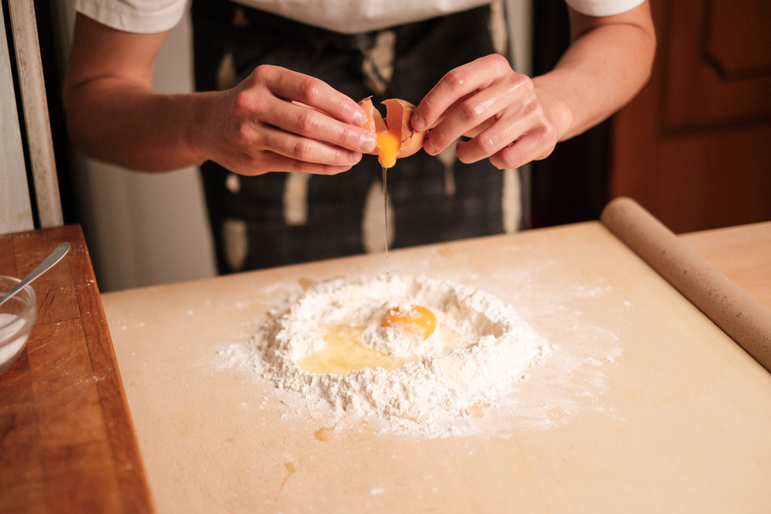 Chef Putting Egg into Flour on the Table