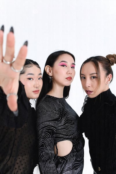 Women in Black Edgy Outfits Posing on White Background