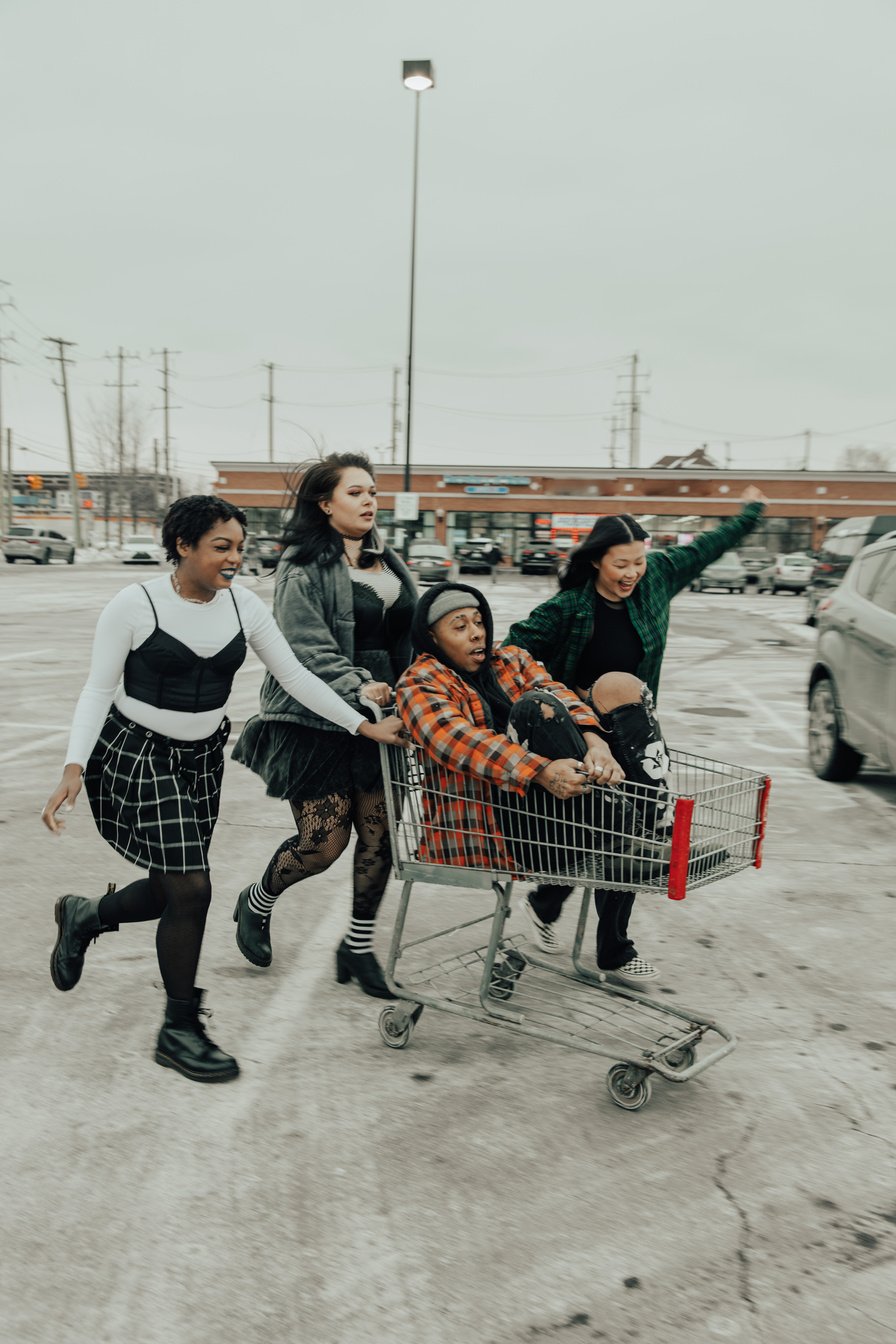 Indie Friends Having Fun with Shopping Cart in Parking Lot