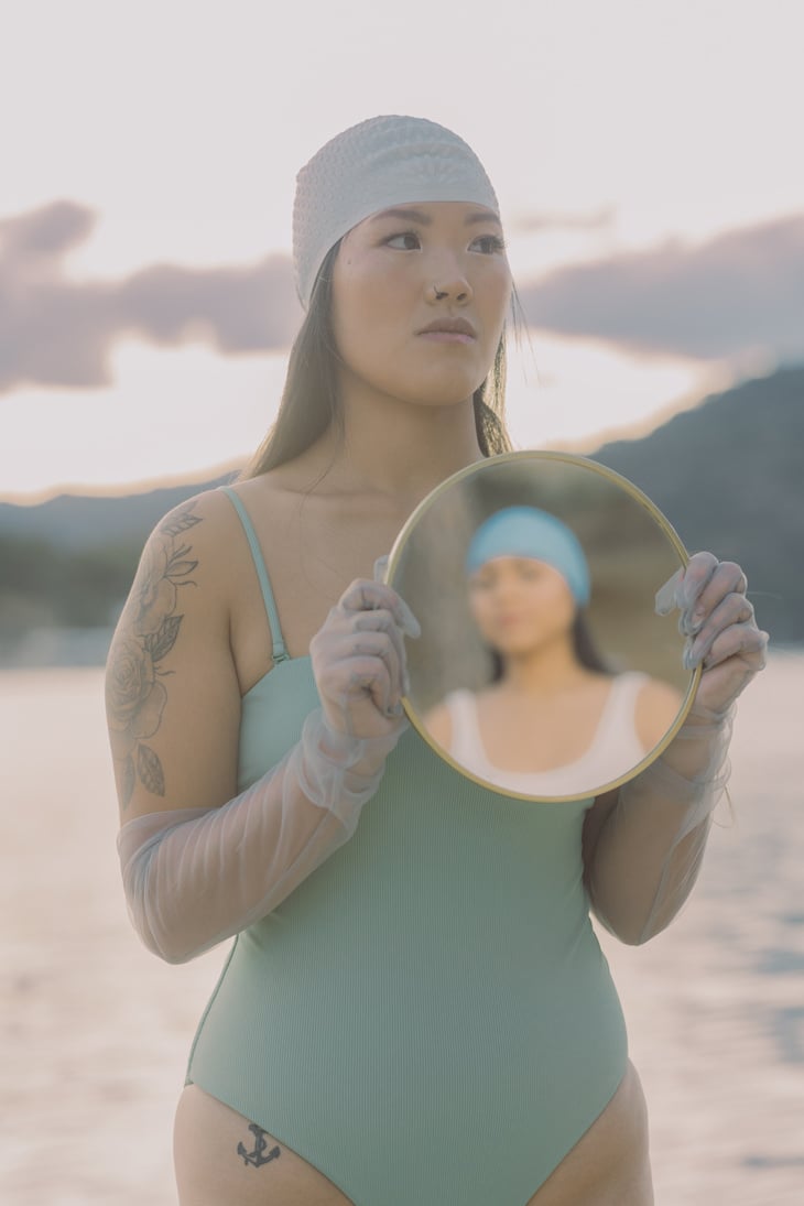 Woman Holding a Mirror with Reflection of a Person