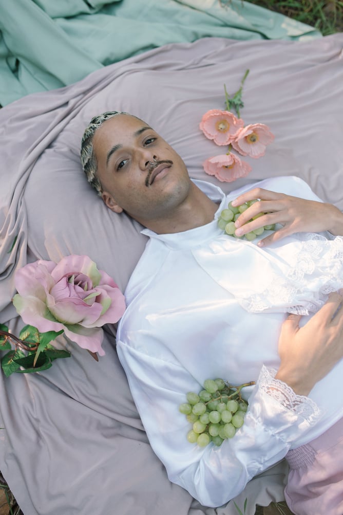 Man Lying in Picnic Ground with Fruits and Flowers 