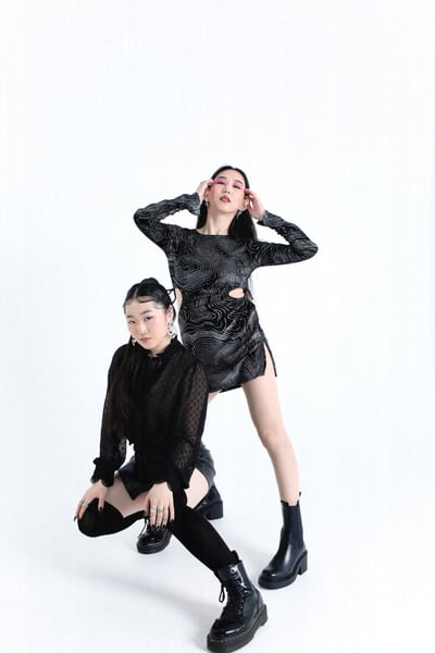 Women in Black Edgy Outfits Posing on White Background