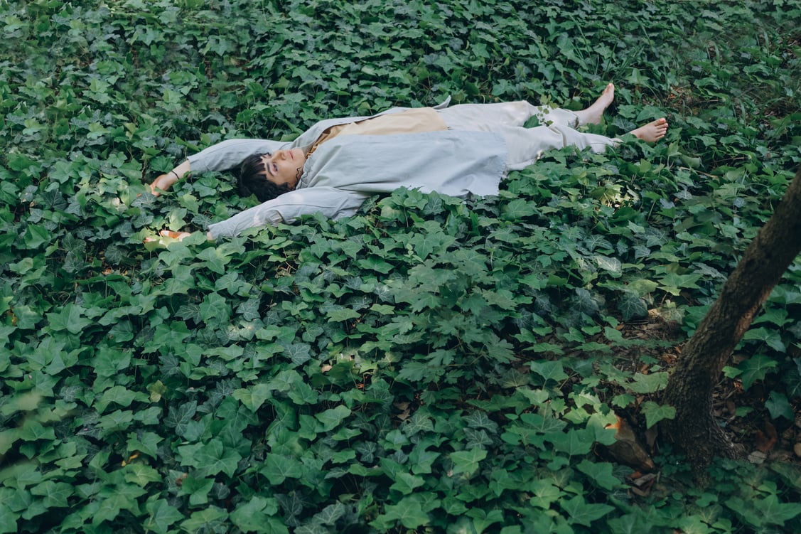 Woman Lying on Grass in Forest